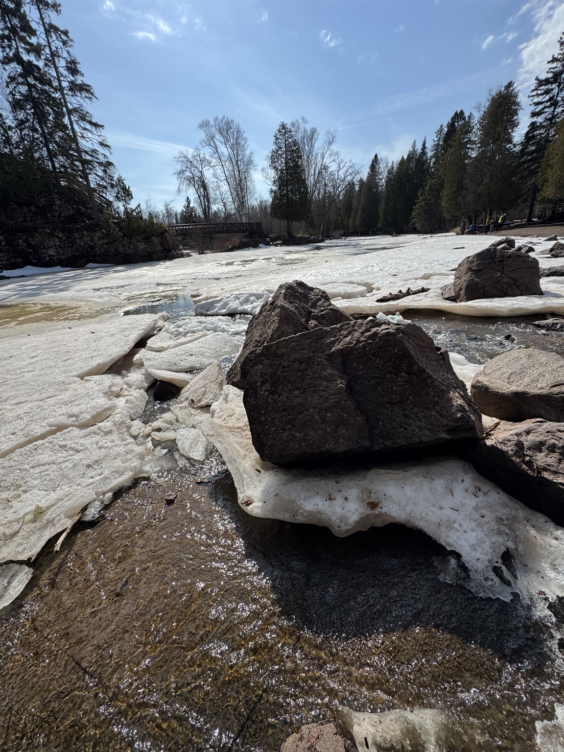 Frozen river with rocks and forest